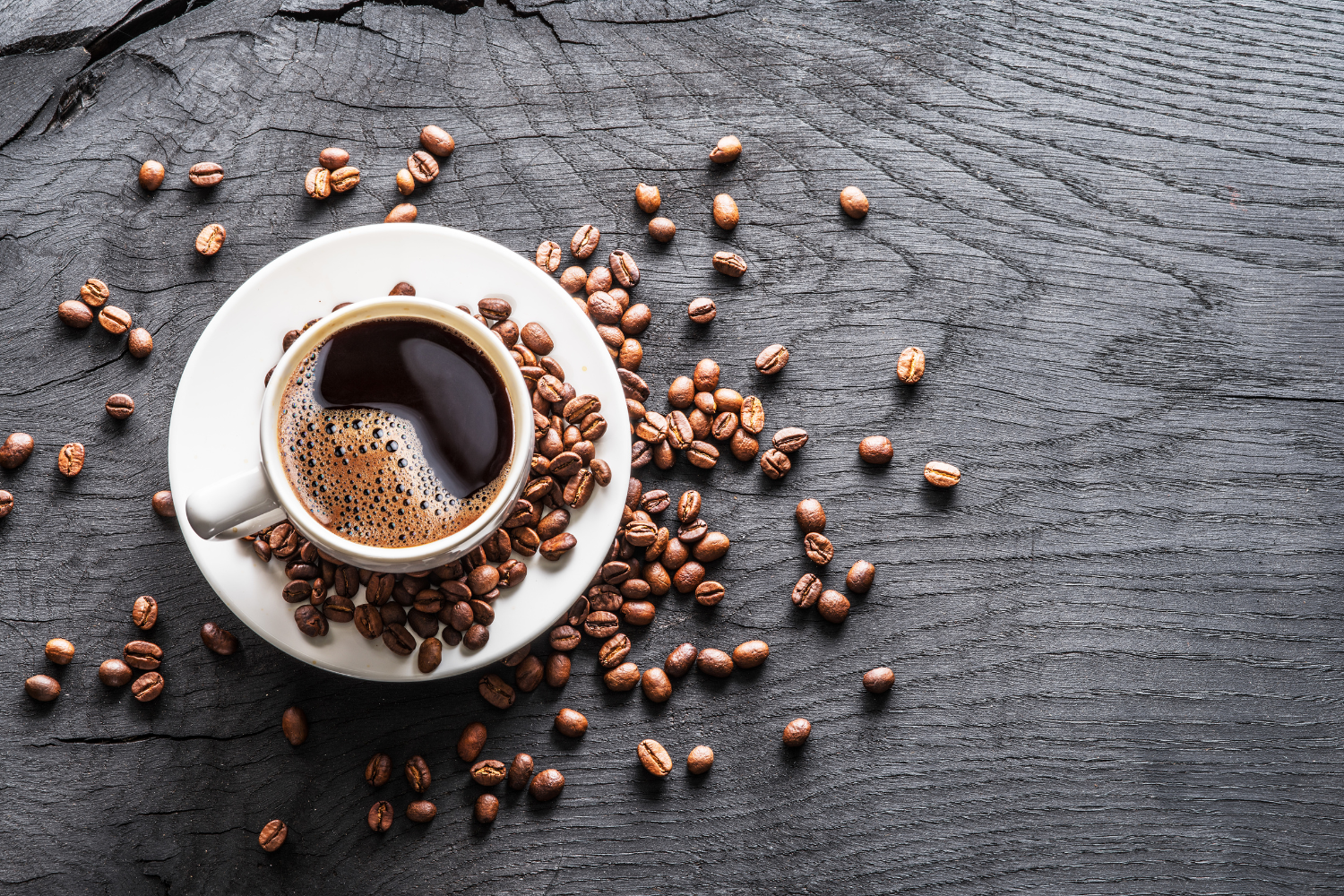 A cup of coffee with coffee beans on a table